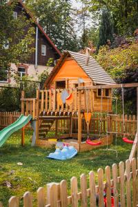 um parque infantil com uma casa e um escorrega em Perła Sudetów by Stay inn Hotels em Karpacz