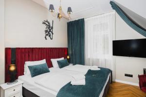 um quarto com uma cama grande e uma televisão em Perła Sudetów by Stay inn Hotels em Karpacz