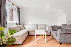 ein Wohnzimmer mit einem Sofa und einem Tisch in der Unterkunft Beautiful Three-Bedroom House in Richmond in Richmond upon Thames