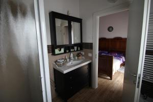 a bathroom with a sink and a mirror and a bed at Mums b and b - colonnina elettrica in Vicenza