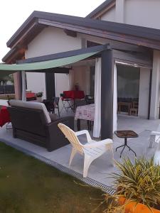 a patio with a couch and chairs and a table at Mums b and b - colonnina elettrica in Vicenza