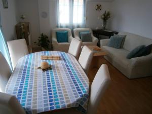 Beautiful holiday apartment Sanela for relaxed vacation في فوديس: غرفة معيشة مع طاولة وأريكة