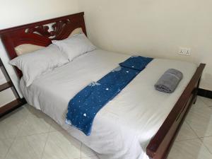 - un lit avec une couverture bleue dans l'établissement Da White Residence Makerere, à Kampala