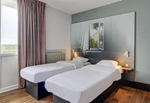 Un pat sau paturi într-o cameră la B&B HOTEL Chaumont