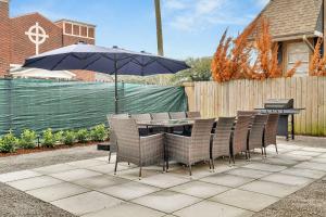 a table and chairs with an umbrella on a patio at Sleeps 22-spacious Suites Near Fq W Pool in New Orleans