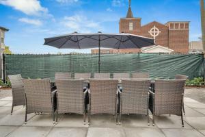 a table with chairs and an umbrella on a patio at Sleeps 22-spacious Suites Near Fq W Pool in New Orleans