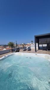 uma grande piscina com uma mesa de piquenique e a praia em Zadar Sunset Penthouse with spectacular view and jacuzzi em Zadar