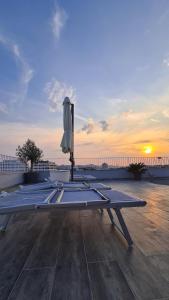 uma mesa com um guarda-chuva num deque com o pôr-do-sol em Zadar Sunset Penthouse with spectacular view and jacuzzi em Zadar