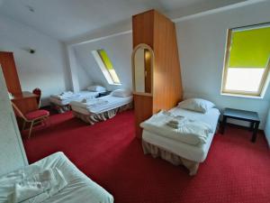 een hotelkamer met drie bedden en een rode loper bij Villa Bella Casa in Łomianki