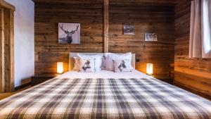 ein Schlafzimmer mit einem Bett in einer Holzwand in der Unterkunft Chalet de ski avec piscine - Megève in Megève