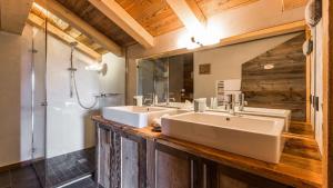 ein Bad mit 3 Waschbecken und einer Dusche in der Unterkunft Chalet de ski avec piscine - Megève in Megève