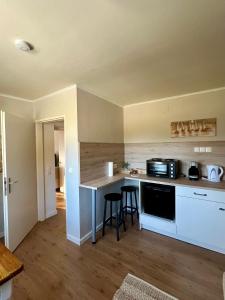 a kitchen with a counter and stools in a room at Tannenhof in Semmering