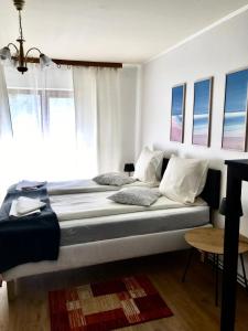 a bedroom with a bed with white walls and windows at Tannenhof in Semmering