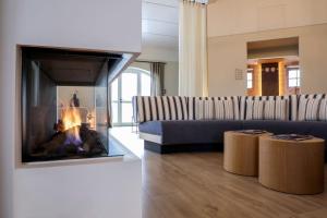 sala de estar con sofá y chimenea en Hotel Gut Immenhof, en Malente