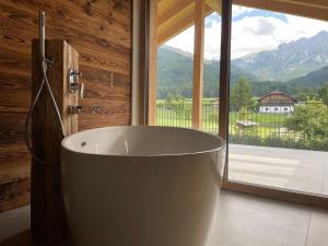 un bagno con ampia vasca e finestra di App Unterhoelzlhof - Chalet Anima a Valdaora