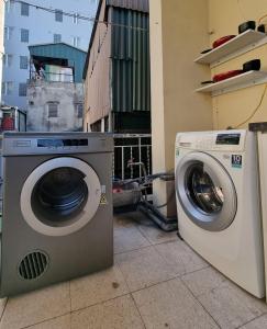 Un lave-linge et un sèche-linge sont installés à côté d'un bâtiment. dans l'établissement LushStay Private Room - Hanoi Train Street, à Hanoï