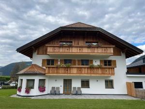 una casa con tetto in legno e balcone di App Unterhoelzlhof - Chalet Anima a Valdaora