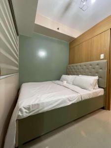 una camera con un letto con una parete verde di Shell Residences front of SM Mall of Asia 1150 a Manila