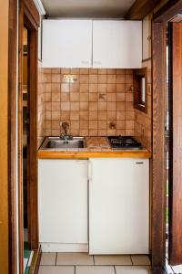 a kitchen with white cabinets and a sink at Villaggio Turistico Camping Cervino in Antey-Saint-André