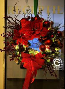 Una corona de Navidad con un arco rojo en una puerta en Pensiunea Carmen - Bikers Friendly Nest, en Sibiu