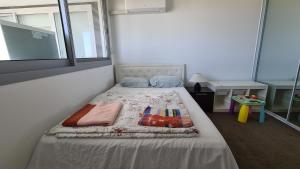 een klein bed in een kamer met een raam bij Spacious 3 bedroom, 2 washroom and 2 parking 5 min from train station in Blacktown