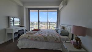 een slaapkamer met een bed, een bureau en een raam bij Spacious 3 bedroom, 2 washroom and 2 parking 5 min from train station in Blacktown