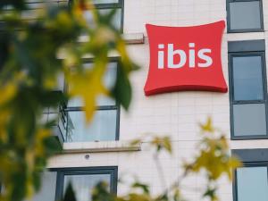 ein Schild an der Seite eines Gebäudes mit Auberginen in der Unterkunft ibis Rouen Centre Rive Droite Pasteur in Rouen