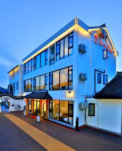 a large white building with a lot of windows at Shanghai Chuxin Moshe B&B Disney Store in Shanghai