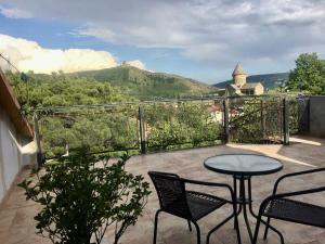 a patio with a table and chairs on a balcony at Anastasia in Mtskheta