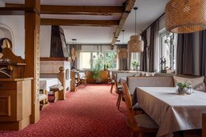 - un restaurant avec des tables et des chaises dans une salle dans l'établissement Der Jagdhof, à Sankt Johann im Pongau