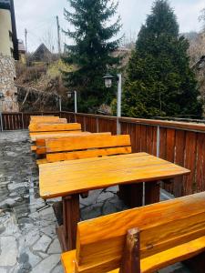 una fila di panche di legno sedute accanto a una recinzione di Nad Grajcarkiem a Szczawnica