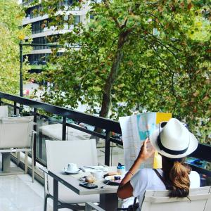 una mujer sentada en una mesa leyendo una revista en Altis Grand Hotel, en Lisboa