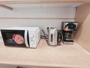 d'un four micro-ondes et d'une cafetière sur un comptoir de cuisine. dans l'établissement Hostel Las Rosas, à Madrid