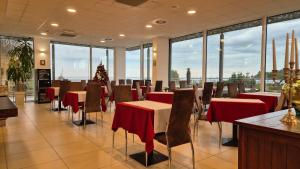 un restaurante con mesas y sillas y un árbol de Navidad en Hotel Lavender - Oleander Resort, en Strunjan