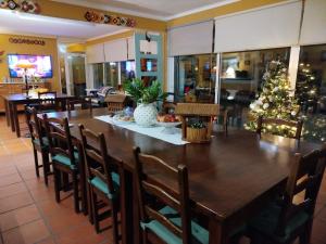 uma sala de jantar com uma mesa grande e uma árvore de Natal em A Casa da Ti Laura - AL em Aveiro