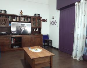 een woonkamer met een tafel en een televisie bij Apartamento en Atlántida, A una cuadra de la Playa y 2 calles del Centro Excelente ubicación in Atlántida