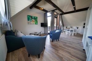 a living room with blue chairs and a couch at Apartments Haus Daniela in Cochem