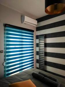 a bedroom with a bed and a window with stripes at fruit tower 300Mbps in Thessaloniki