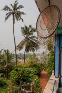 アランボールにあるDreamcatcher House & Hostel at Arambol Beachの椰子の木が茂る家の横掛け