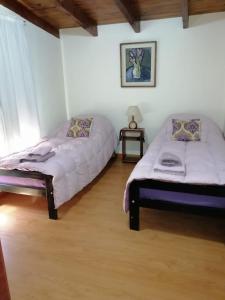 um quarto com duas camas e uma mesa de cabeceira em Bed and Breakfast Como en Casa em Villa La Angostura