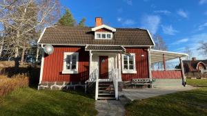 una pequeña casa roja con una puerta blanca en Villa Victoria, en Mariannelund