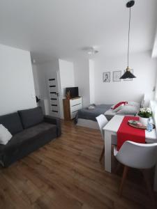 ein Wohnzimmer mit einem Sofa und einem Tisch in der Unterkunft Apartament in Ostrołęka