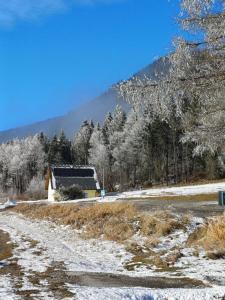 斯坦豪斯阿赛姆瑞Appartements Dorner的雪地覆盖,后方有谷仓