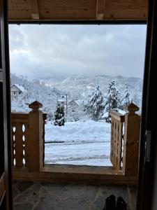 Blick auf einen schneebedeckten Hof aus einem Fenster in der Unterkunft Casa Berg in Vişeu de Sus