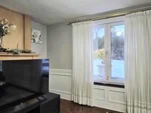 una sala de estar con una gran ventana con cortinas blancas en Deluxe Private Room in Toronto, en Toronto