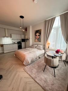 een grote slaapkamer met een bed en een tafel bij Studio Lage Rijndijk in Leiden