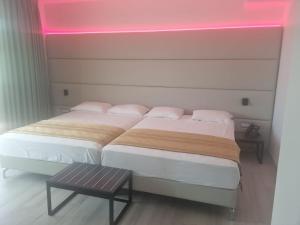 2 Betten in einem Zimmer mit rosa Licht in der Unterkunft HOTEL VENICE BEACH HVB 34 Lifestyle 4 Superior in Bibione