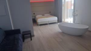 Zimmer mit Badewanne und Bett in der Unterkunft HOTEL VENICE BEACH HVB 34 Lifestyle 4 Superior in Bibione