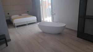 eine große weiße Badewanne in einem Zimmer mit einem Bett in der Unterkunft HOTEL VENICE BEACH HVB 34 Lifestyle 4 Superior in Bibione