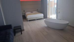 ein Bad mit einer Badewanne und einem Bett in der Unterkunft HOTEL VENICE BEACH HVB 34 Lifestyle 4 Superior in Bibione